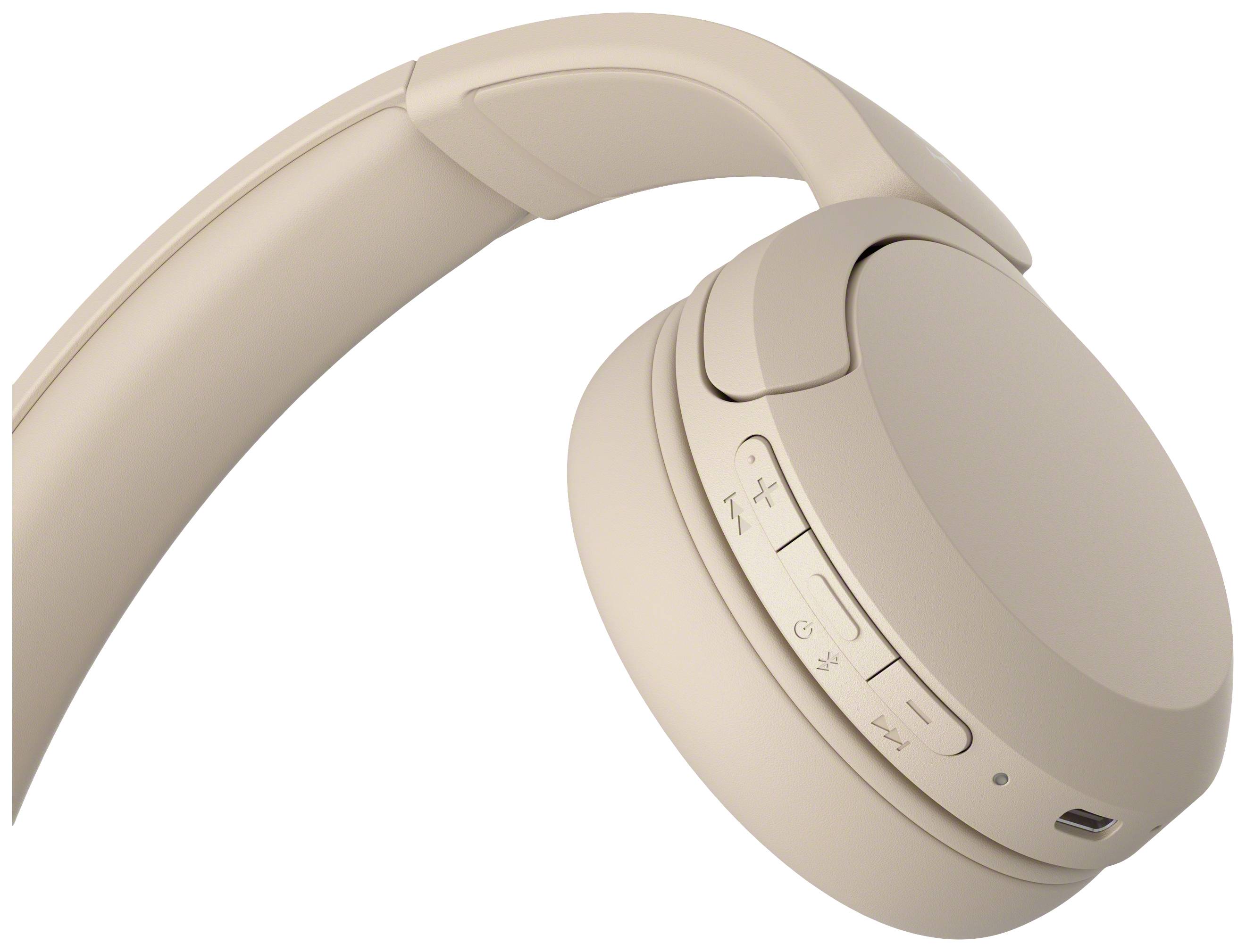 Beige headphones with multiple control buttons on the side, showing modern design and wireless functionality.