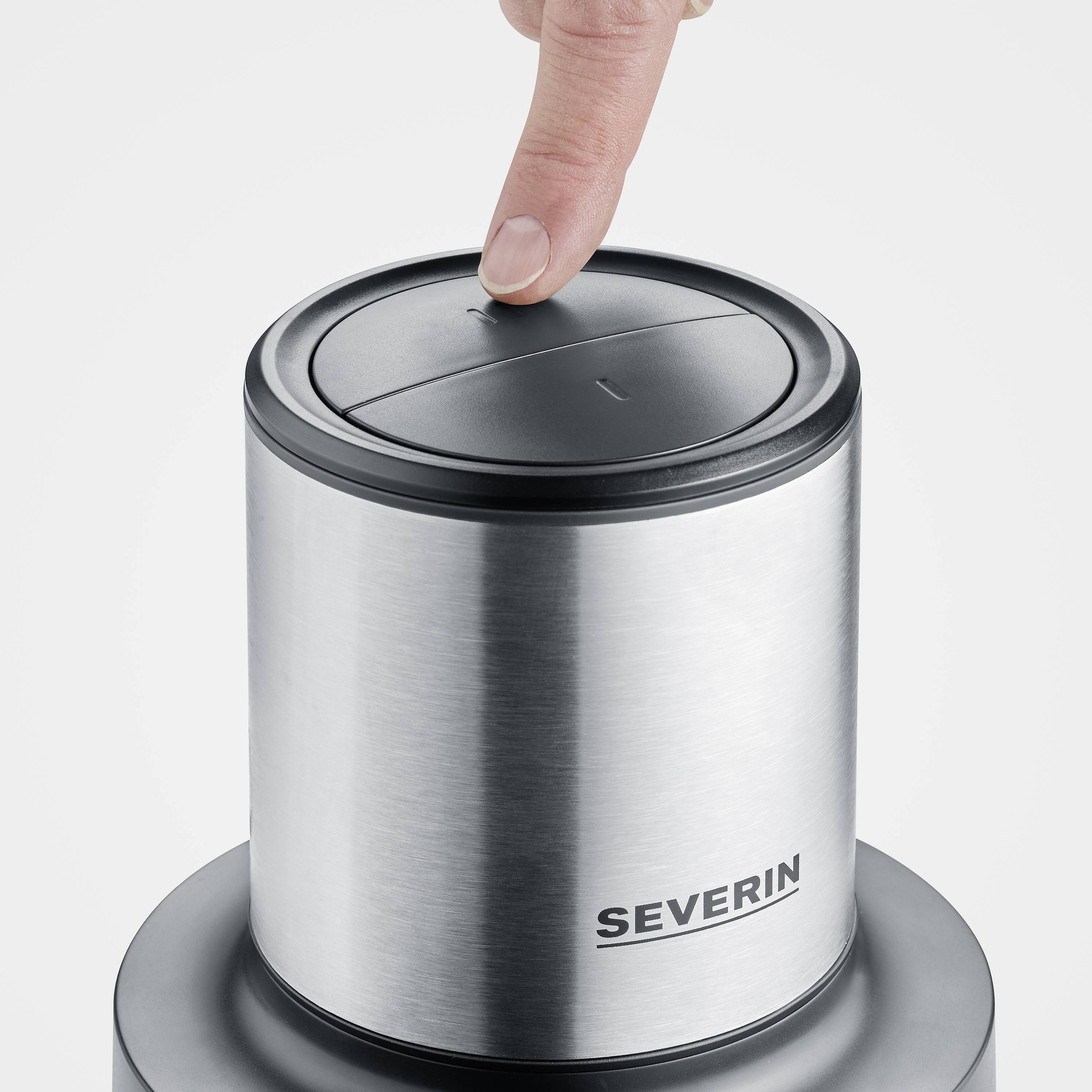 A person is pressing down on the lid of a stainless steel container labelled 'Severin'.