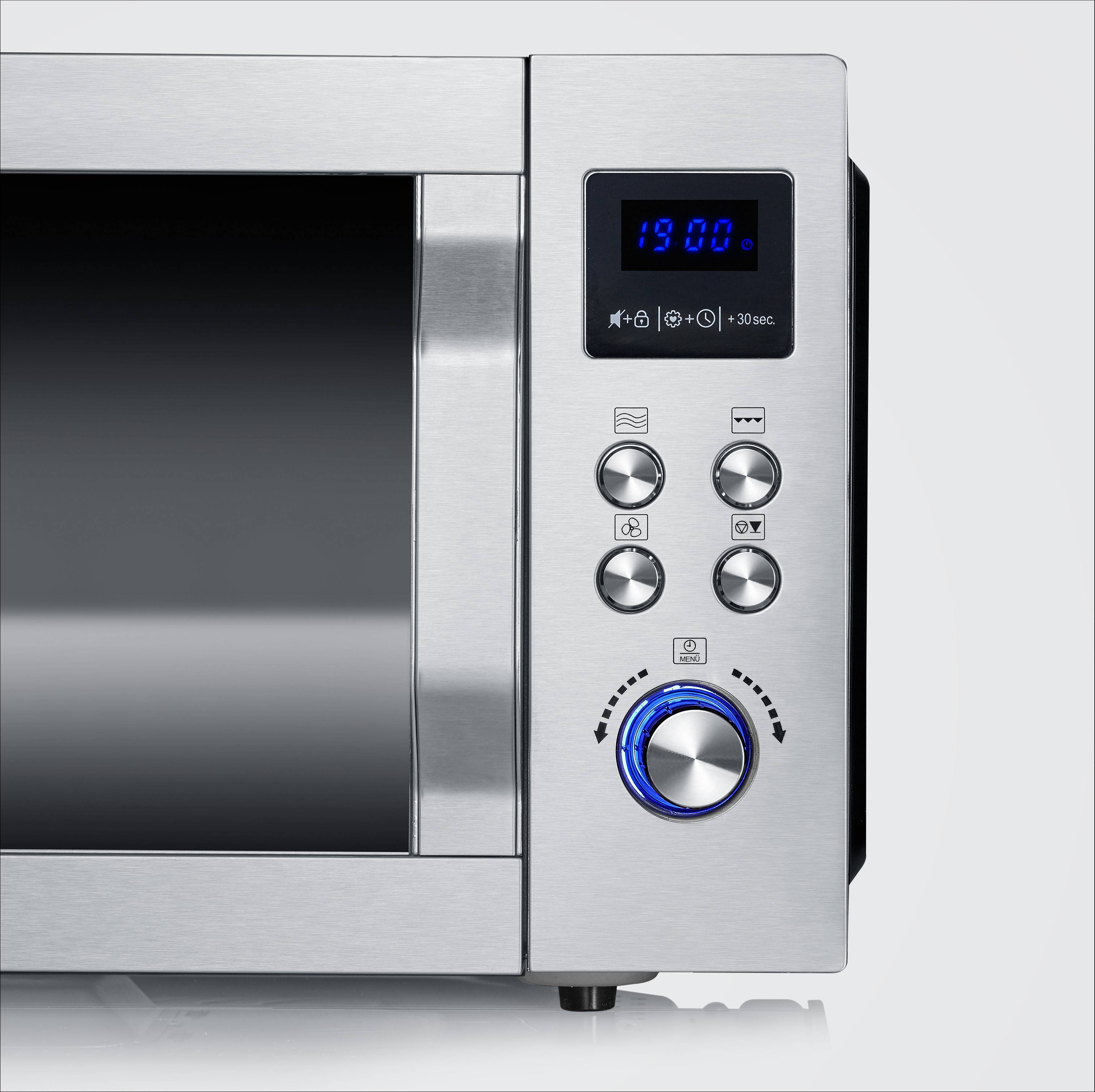 Silver microwave with digital display showing '19:00', buttons and rotary dial. Suitable for heating or defrosting food.