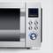 Silver microwave with digital display showing '19:00', buttons and rotary dial. Suitable for heating or defrosting food.