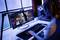 A person is working on a computer with a large monitor and microphone, possibly streaming or video editing.