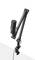 Black microphone on a flexible stand, attached to a table edge, suitable for sound recordings or podcasting.