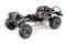 Remote-controlled car chassis with exposed frame and large, robust tyres. Electronic components and cables visible.