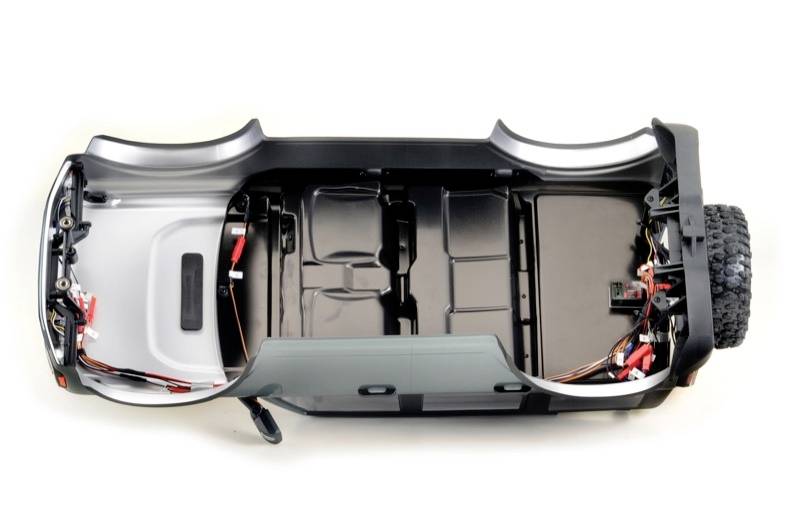 'Top-down view of an electric vehicle chassis showing the visible battery compartment and electrical wiring.'