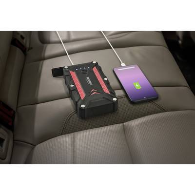 An external power bank is charging a smartphone on a car seat.