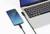 A smartphone is connected to a laptop and charged via a USB cable. The charging screen displays a green battery icon.