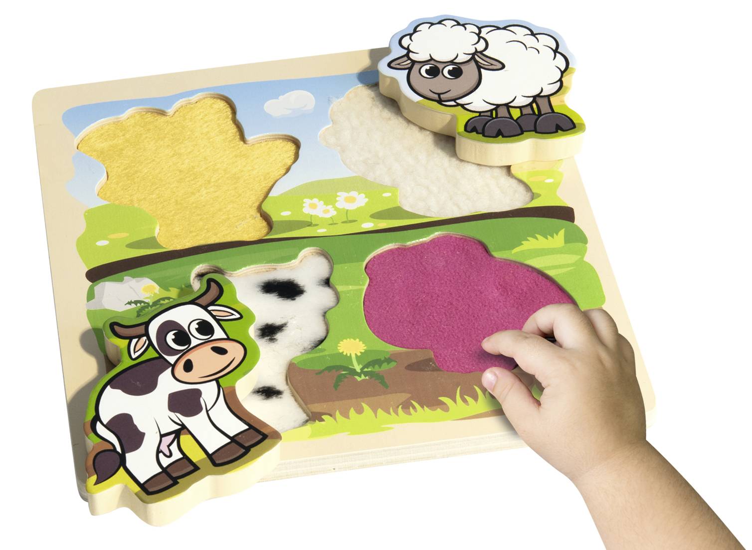 A child places a sheep puzzle piece on a puzzle board. Next to it is a cow puzzle piece. The background shows a green meadow.