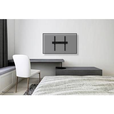 A slim television wall mounting system in a minimalist bedroom, with the television yet to be installed.