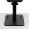 A black monitor stand by Neomounts with a square base and sturdy, vertical column against a light background.