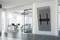 Office with contemporary furniture, empty desks and a large screen mounted diagonally high on the wall.