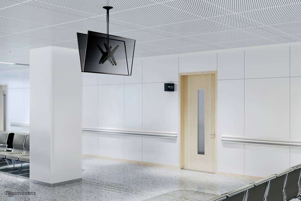 Waiting area with empty chairs, white interior and a suspended screen with no display.