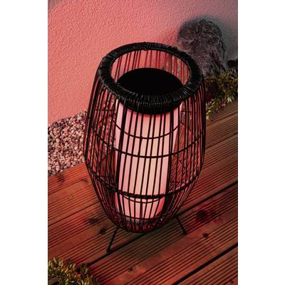 Basket lantern with red light on wooden flooring, surrounded by stones and plants, creates an atmospheric lighting.