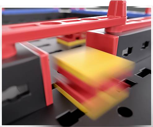 A black board with red and yellow movable plastic parts, possibly a learning toy or an educational model.