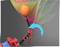 A robotic arm bends a coloured piece of paper printed with 'fischertechnik'. A blue arrow indicates the direction of movement.