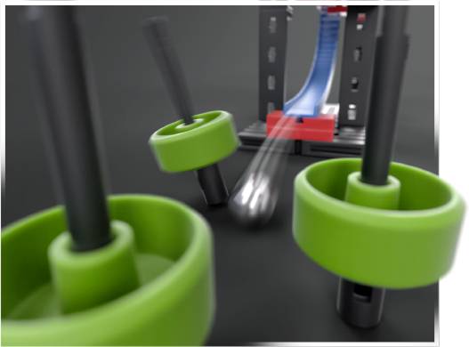 A toy marble run set shows a metal ball in motion passing through green, rotating obstacles on a black base.