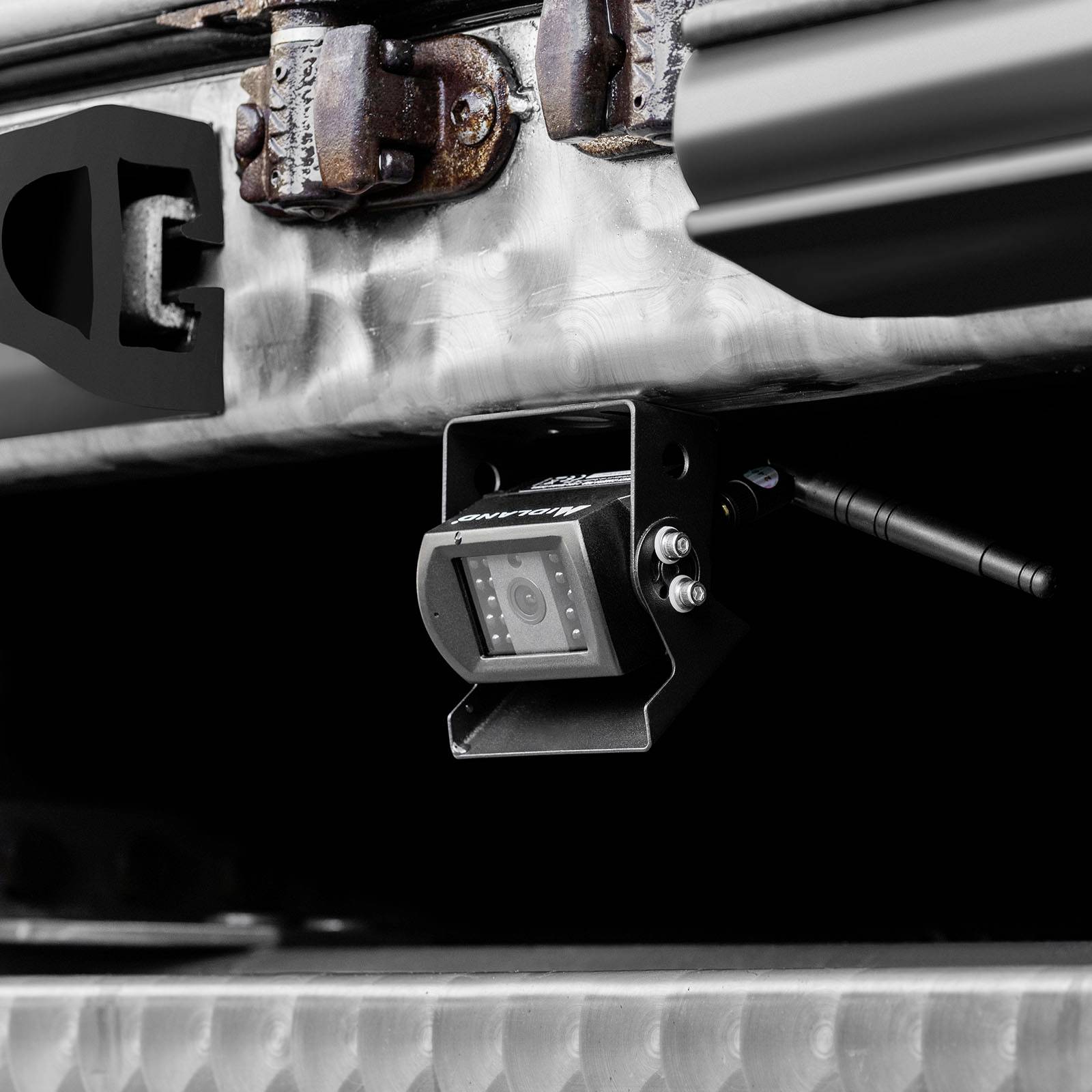 Close-up of a reversing camera and tow bar on a vehicle. The camera is mounted beneath the coupling and faces backwards.