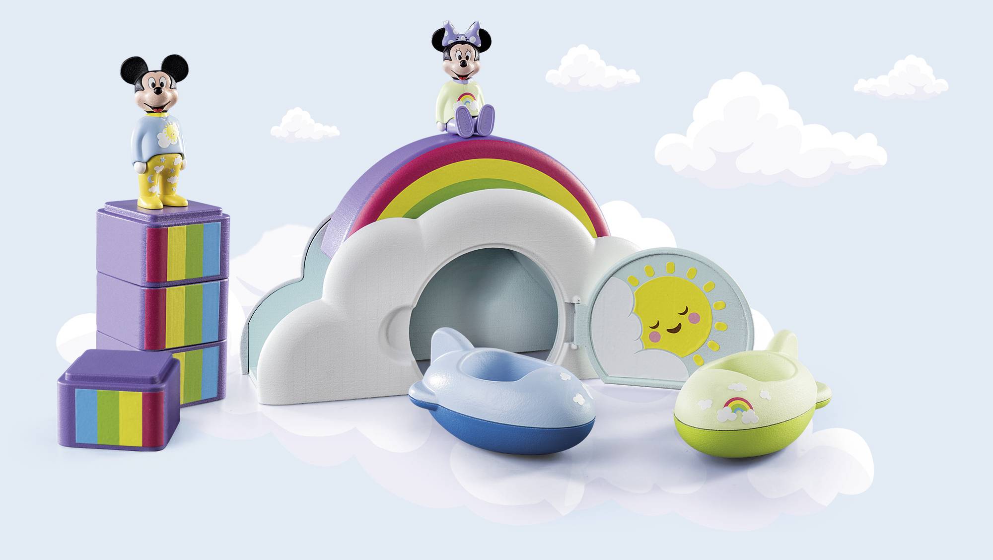 Toy set featuring a rainbow, clouds, two aeroplanes, and two figures in colourful outfits standing on a cloud. Background with additional clouds.