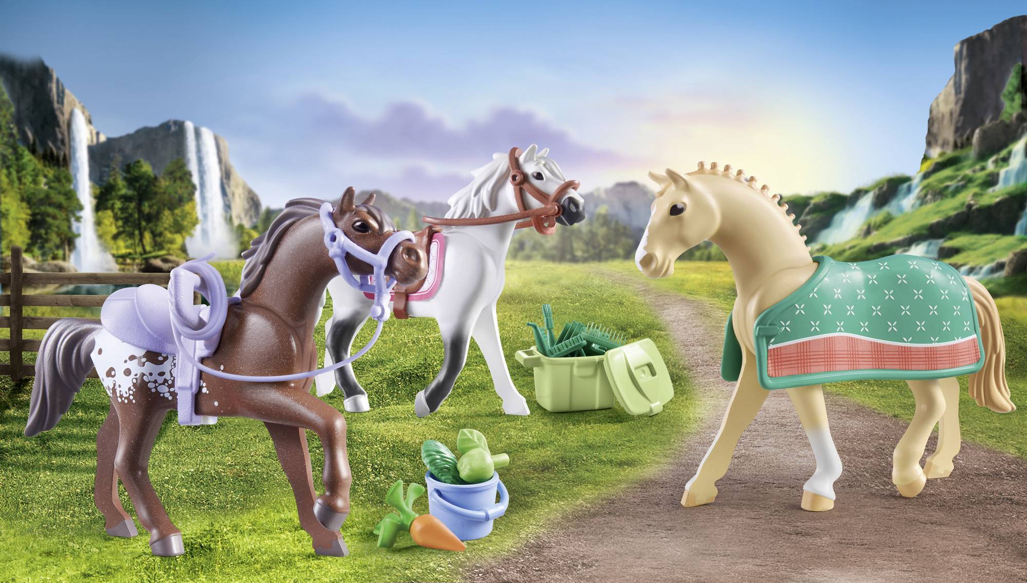 Three toy horses stand on a path with waterfalls in the background; a crate of vegetables is beside them.