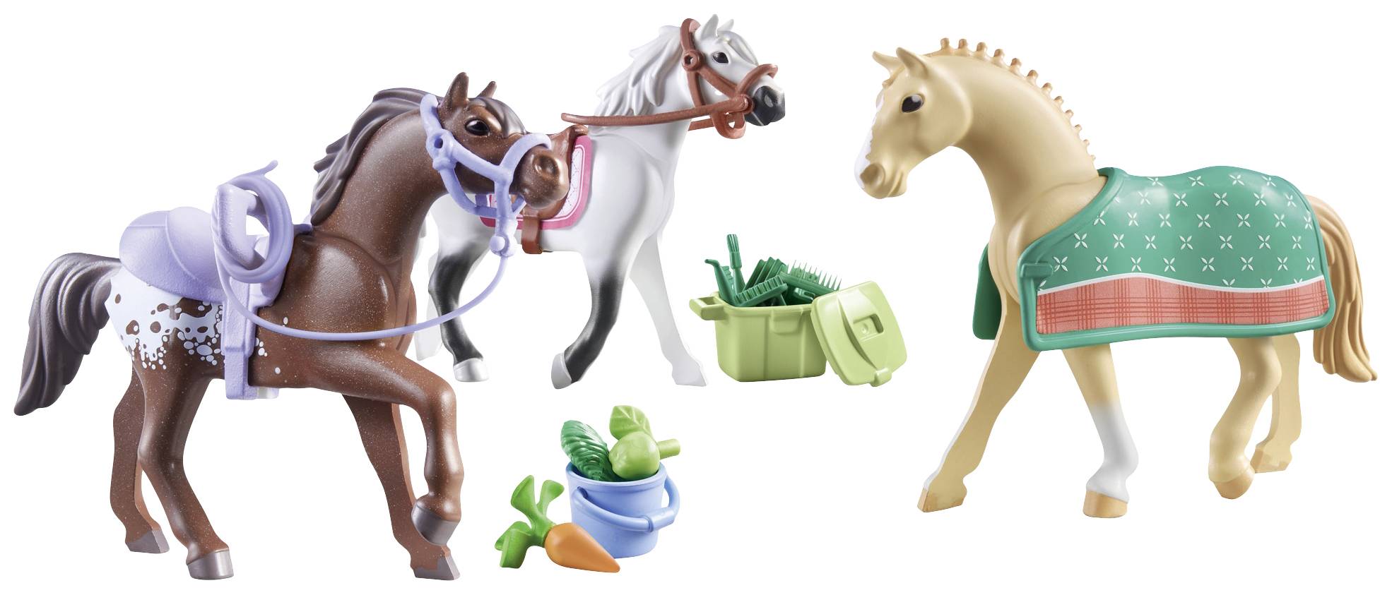 Three toy horse figurines in different colours, equipped with saddles and bridles, surrounded by accessories such as carrots and brushes.