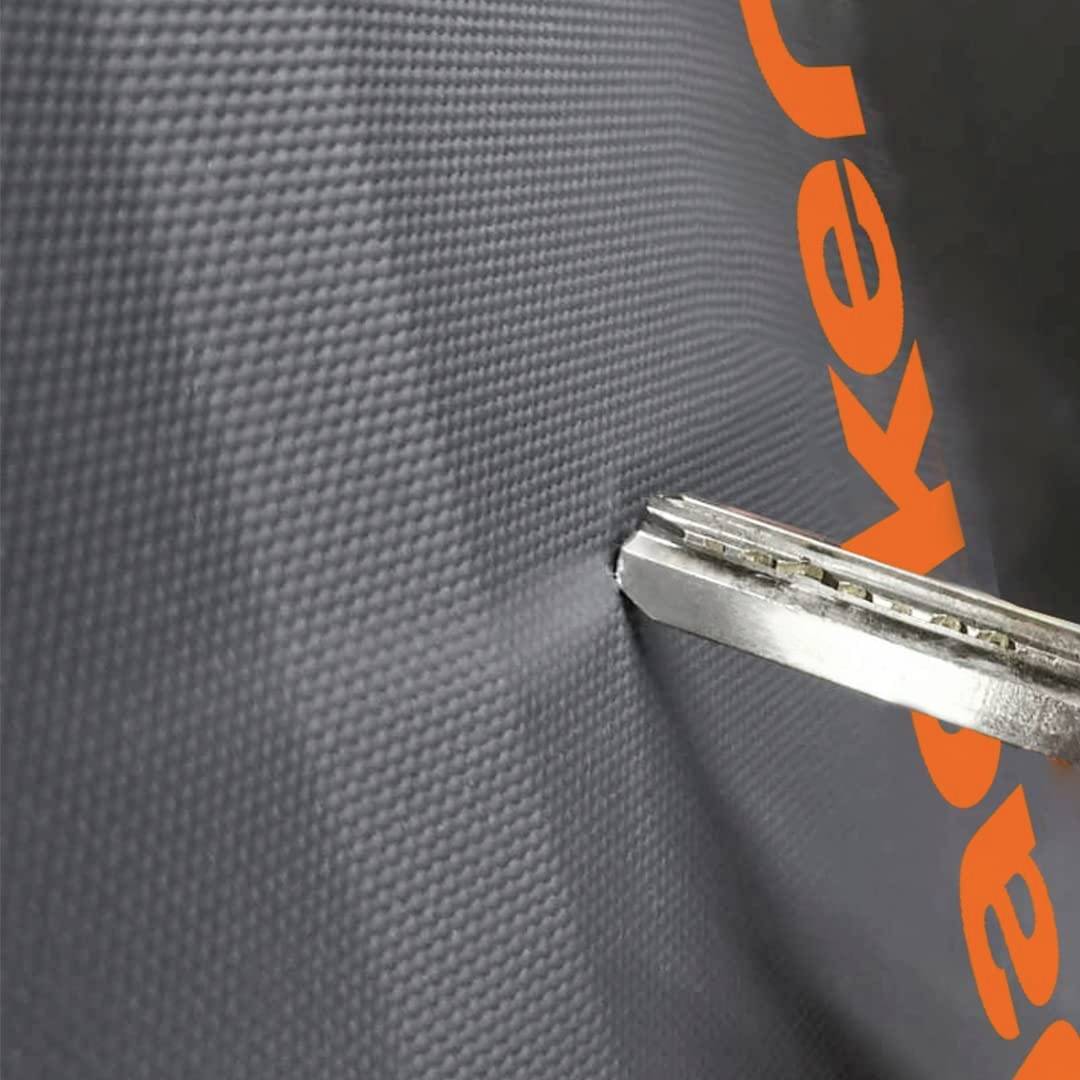 A silver penknife cuts through black material with an orange inscription.