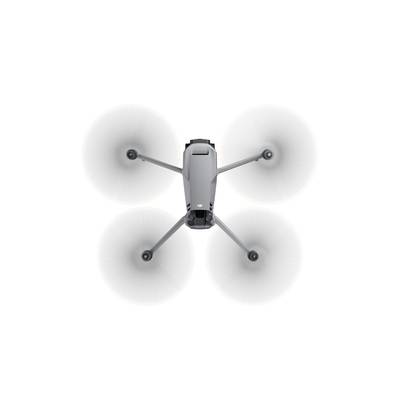 Drone in flight viewed from above, with four rotating propellers evenly distributed around the body in the centre.