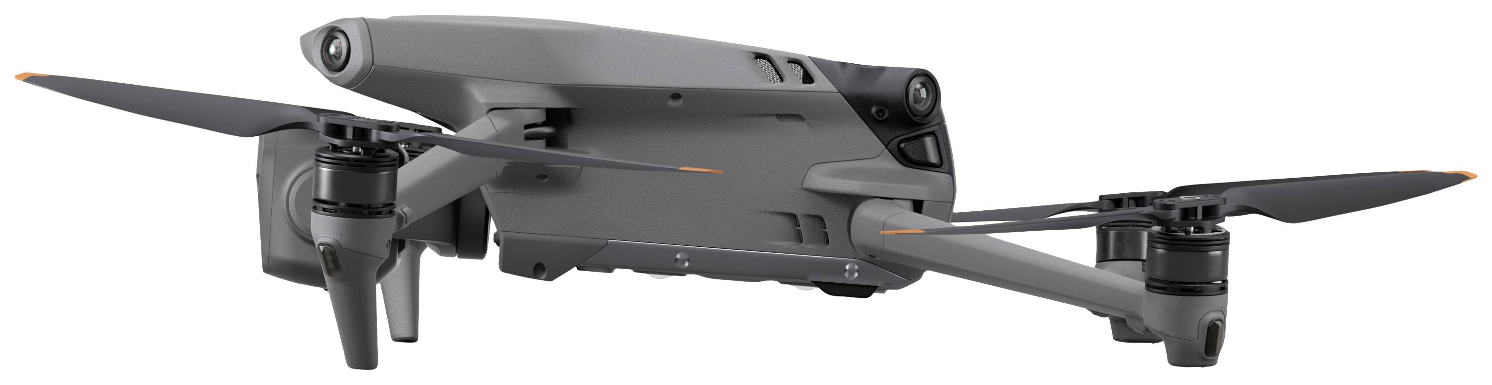 A grey drone with four rotors is flying in the air. It has a sleek design and is pictured against a light background.