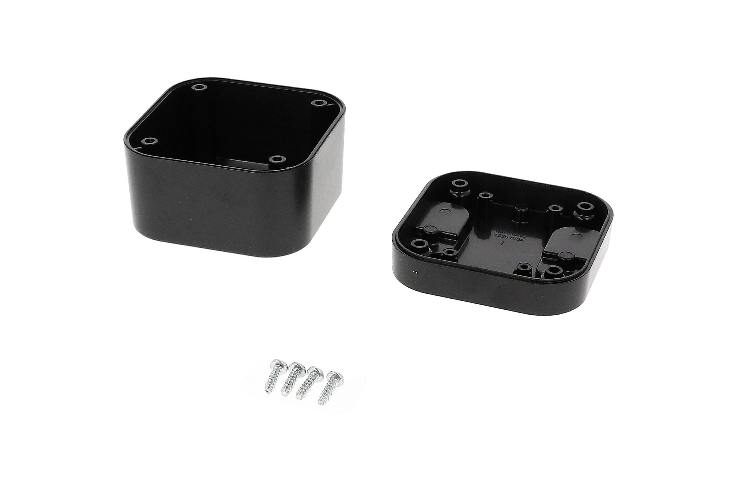 A black, rectangular plastic box in two parts next to four screws on a white background.