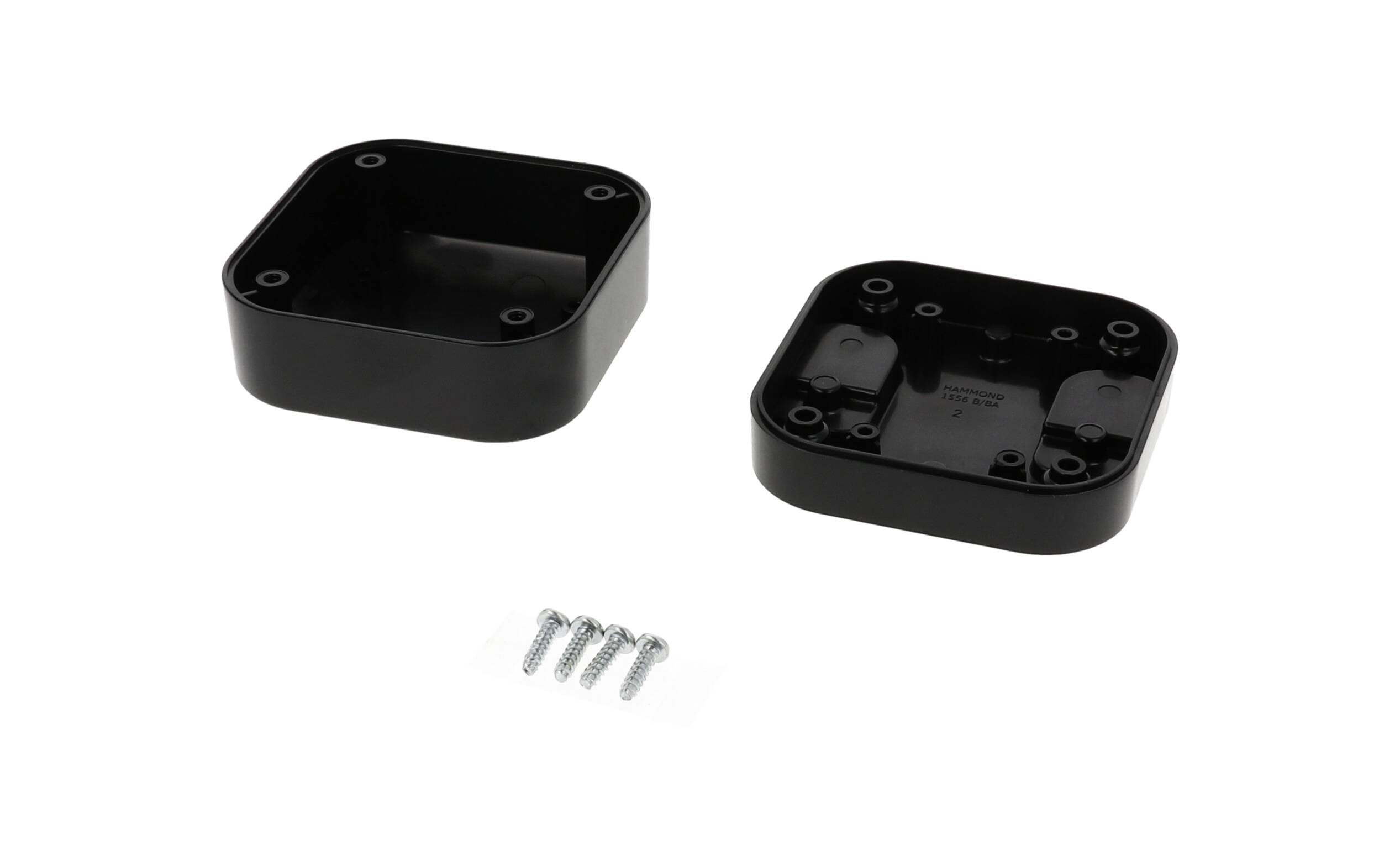 Two black plastic housing parts side by side with four screws in the centre.