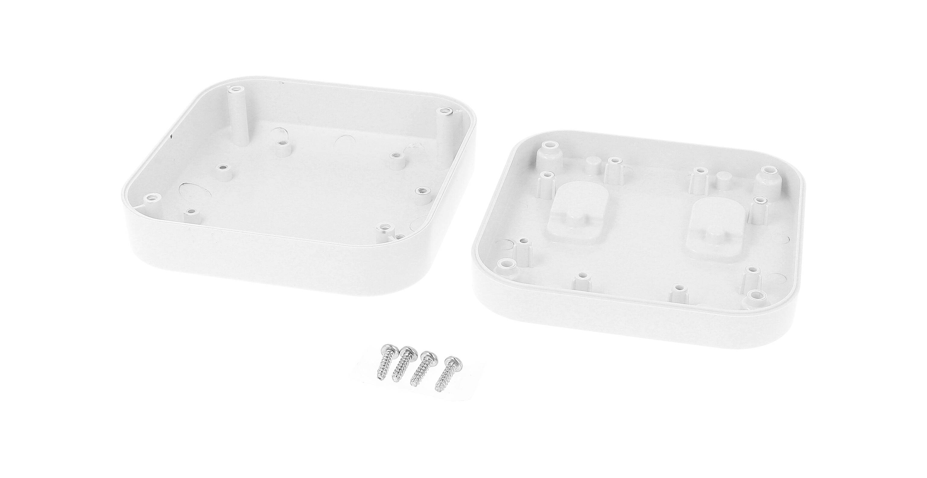 Two-part white plastic casing, opened. Contains four screws for joining the casing parts.