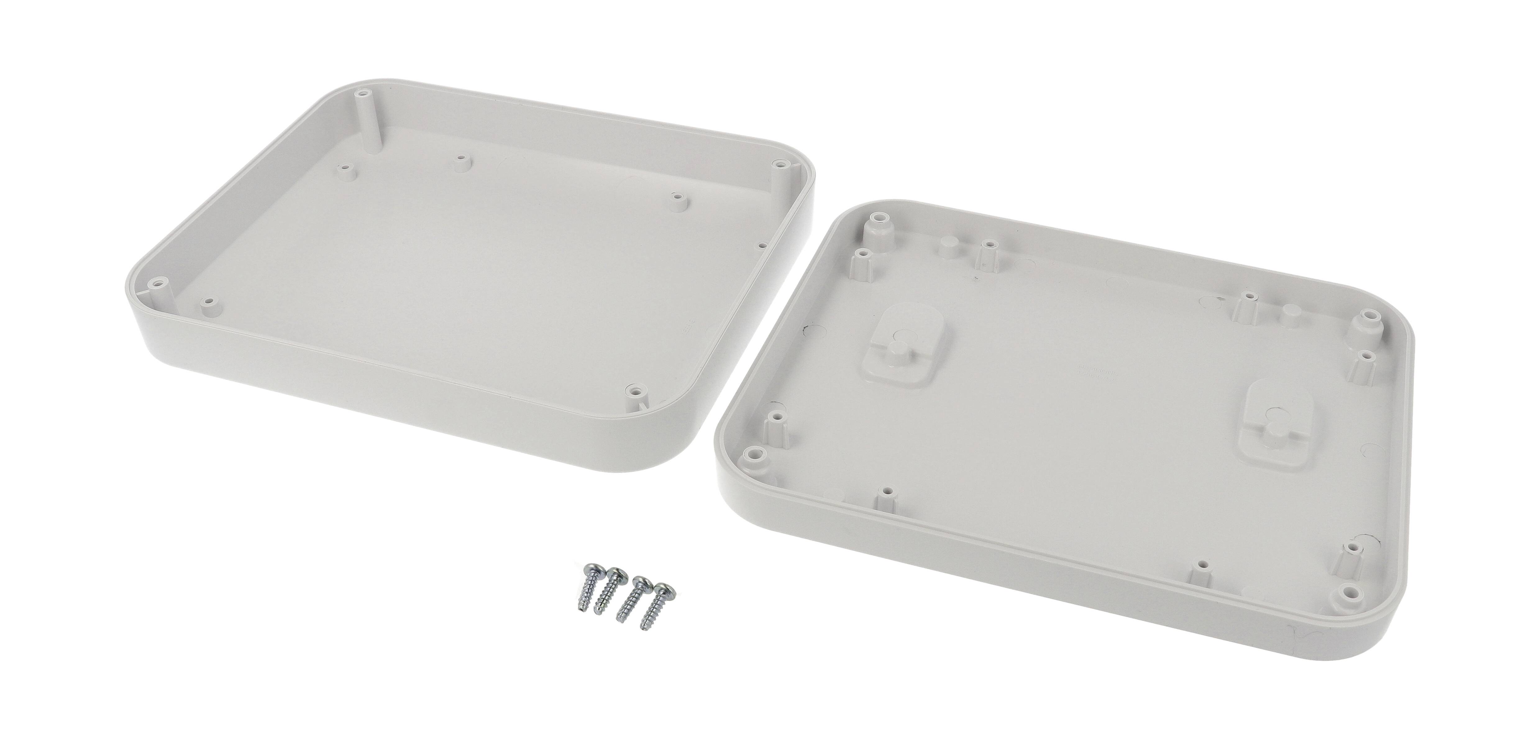 Two white plastic housing covers, opened; four screws alongside, identical in shape. Housing suitable for electrical or electronic devices.