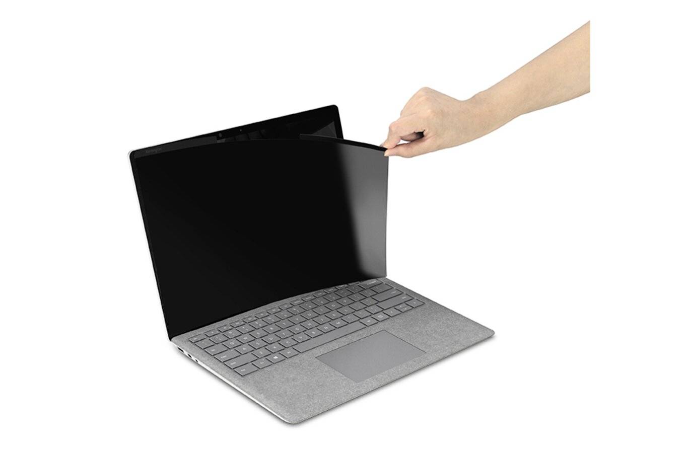 A hand is placing a privacy filter on the screen of an open laptop to protect privacy.