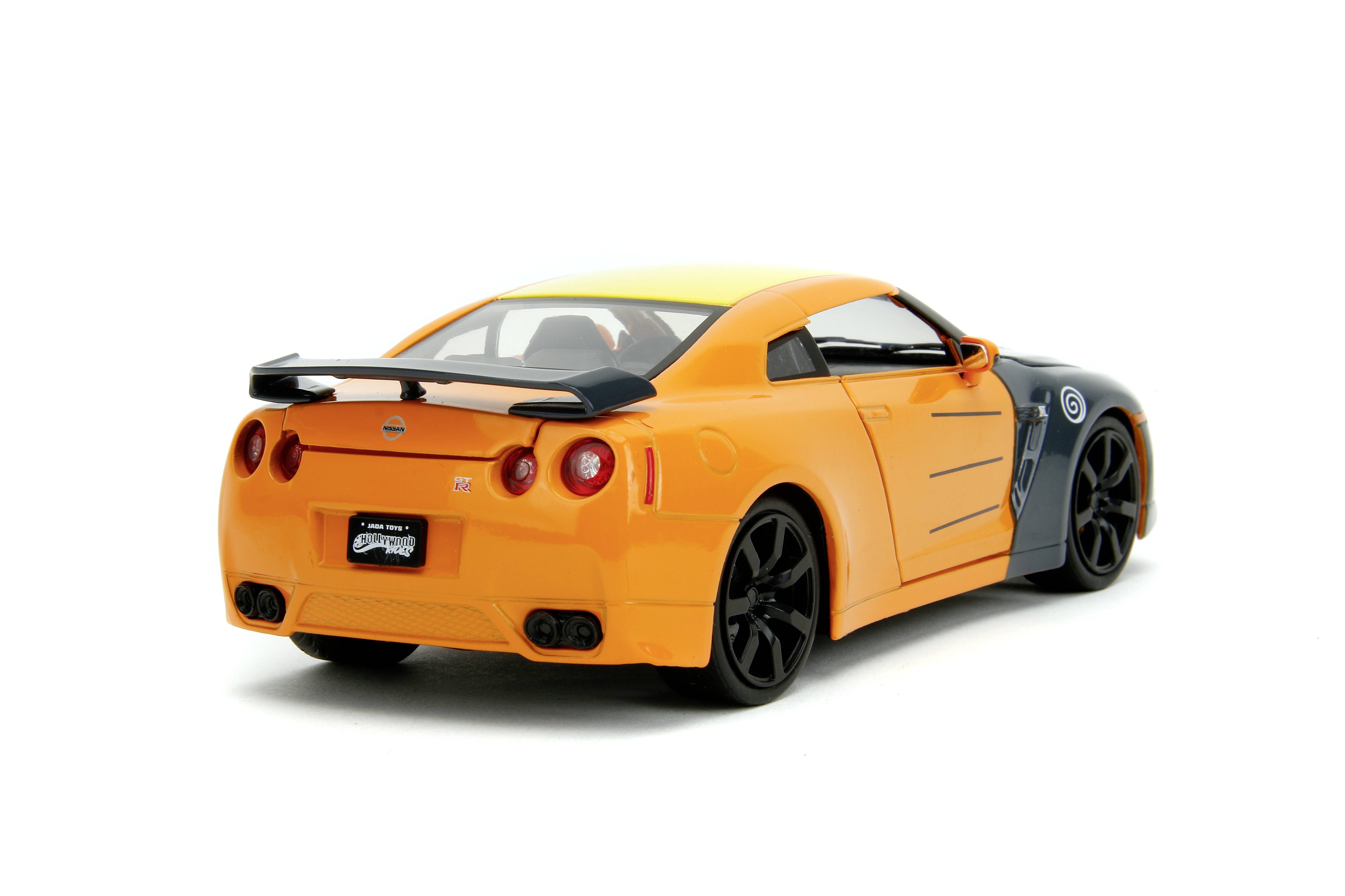 An orange and black sports car is positioned sideways, with its rear end visible. The car has a spoiler and black alloy wheels.