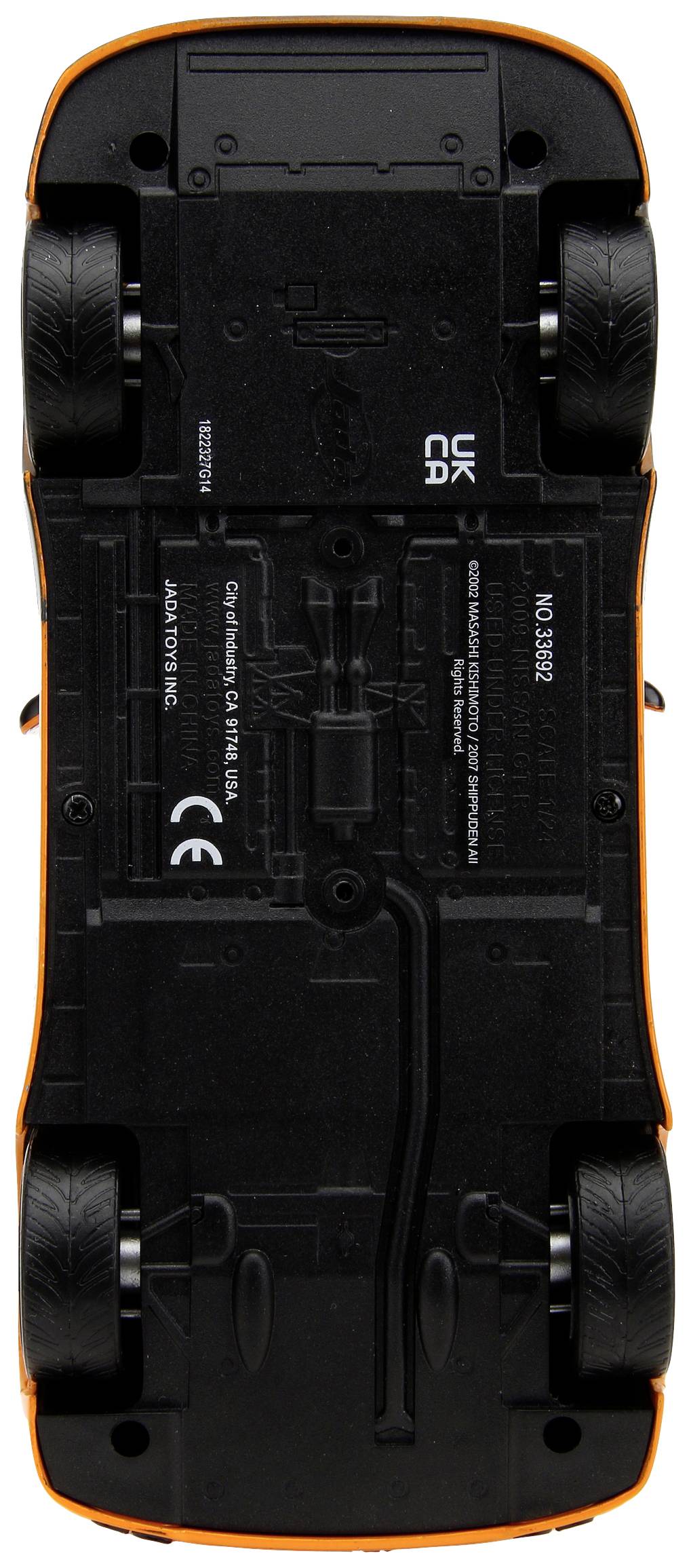Underside of a toy car, black with an orange border. Visible tyres and marked components, revealing mechanical details.