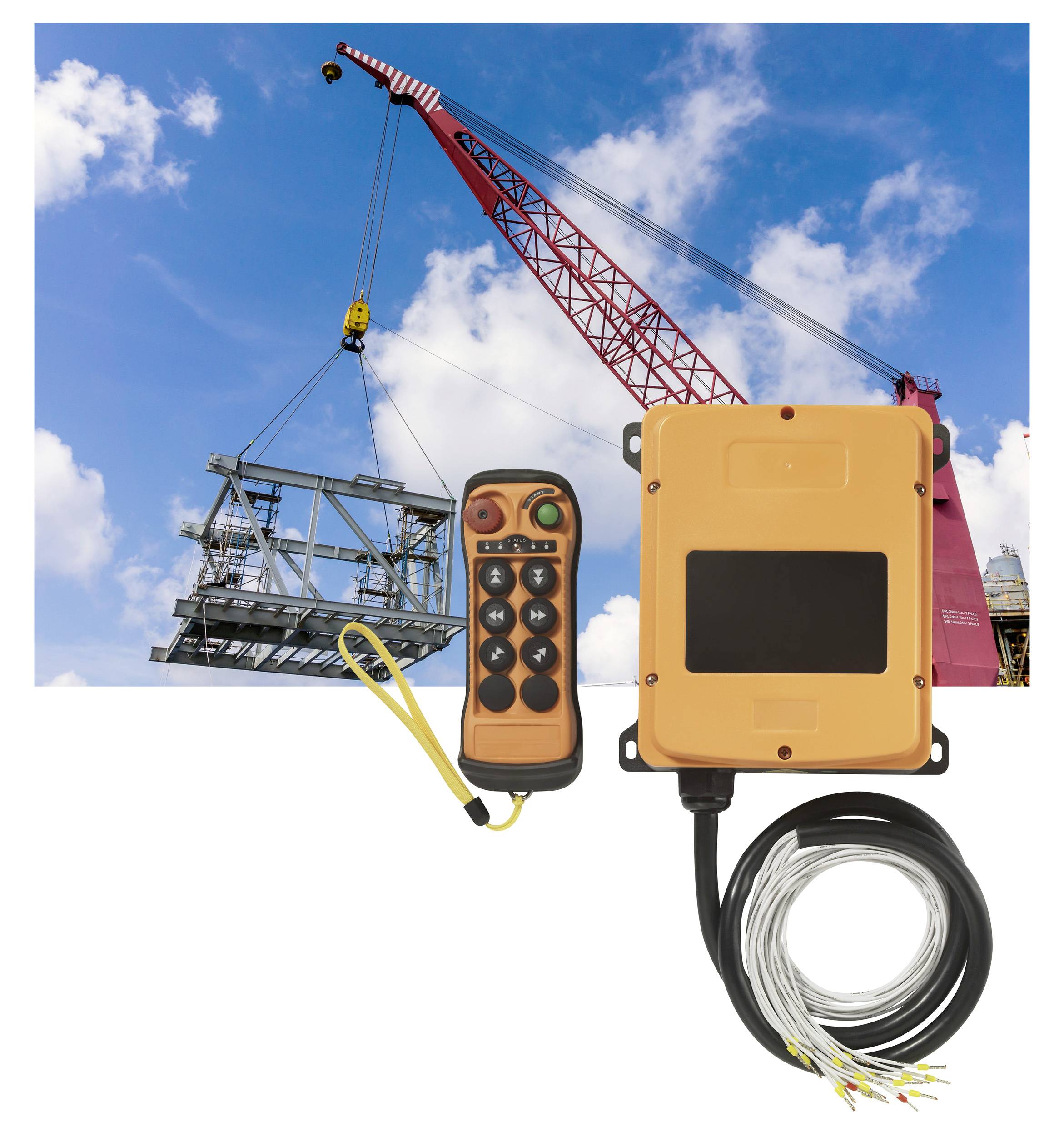 A red construction crane lifts a metallic structure into the sky. Beside it are an orange remote control and an electrical control unit.