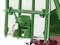 Green mechanical structure with lever and red arrow indicating direction of movement. Mounted on a vehicle, detail of a loading ramp system.