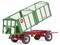 A green agricultural trailer with red wheels is tipping sideways. Brand logos are visible.