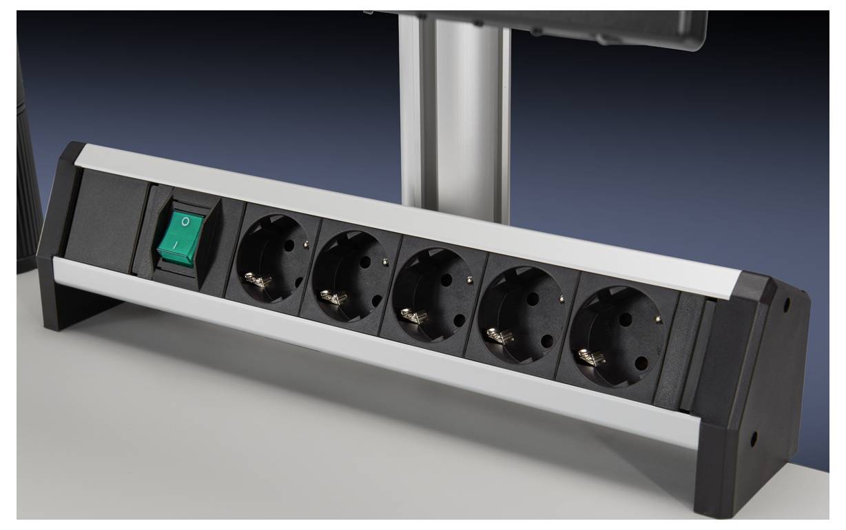 A five-socket extension lead with a green on/off switch placed on a table.