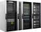 'Three open server racks with computers and network cabling in a technical room, revealing various hardware components.'