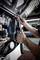A person is adjusting a large wrench on a truck engine, focusing on a specific part. The image highlights mechanical repair work.