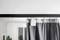 A curtain with an automatic sliding system, suspended from a black curtain pole, in a bright room with a mirror.