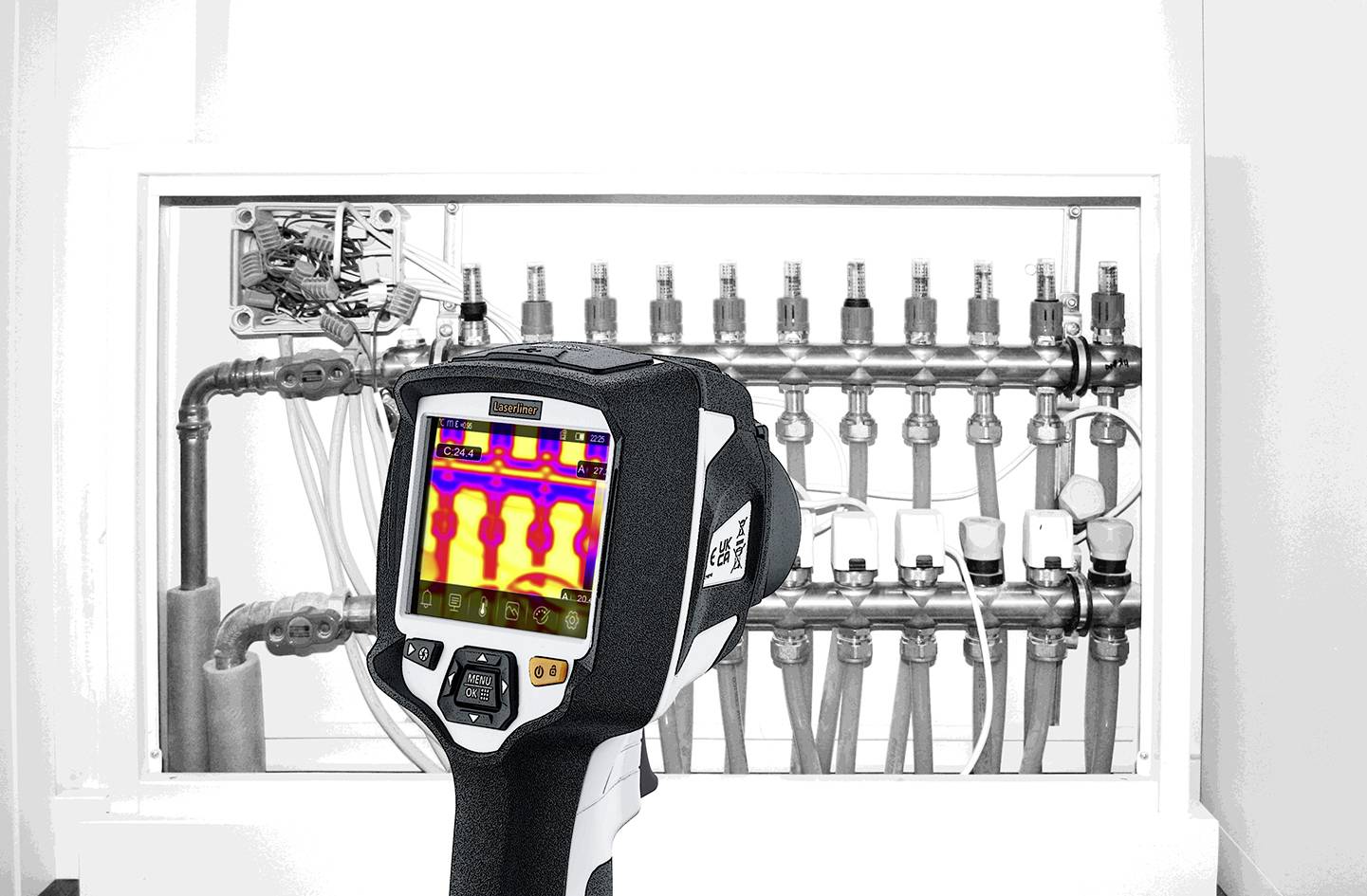 Thermal imaging camera shows the thermal distribution of a heating system with multiple valves and pipes.