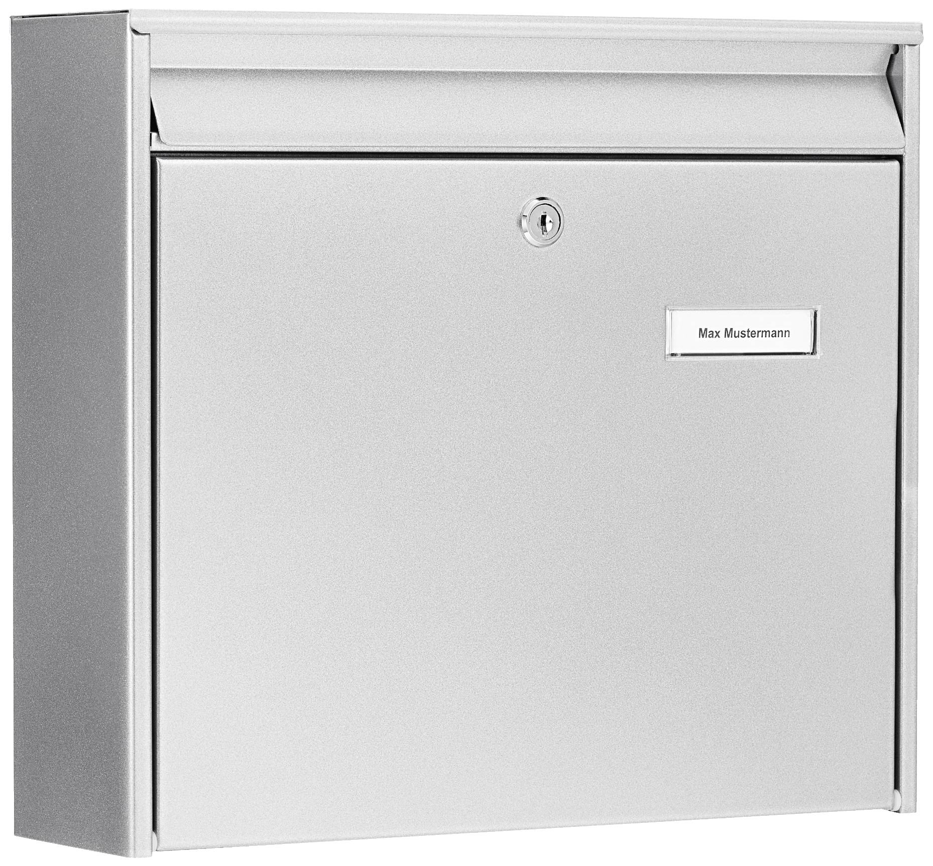A silver letterbox with a name plate reading 'Max Mustermann'. The letterbox has a lock in the centre.