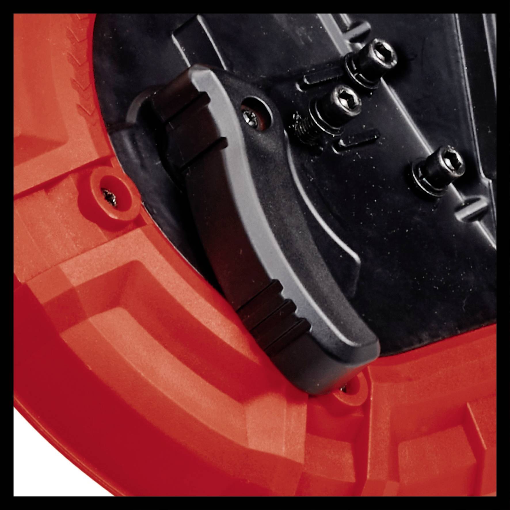 Red and black cable reel, close-up. Shows handle and fixing screws, detail of robust plastic material.