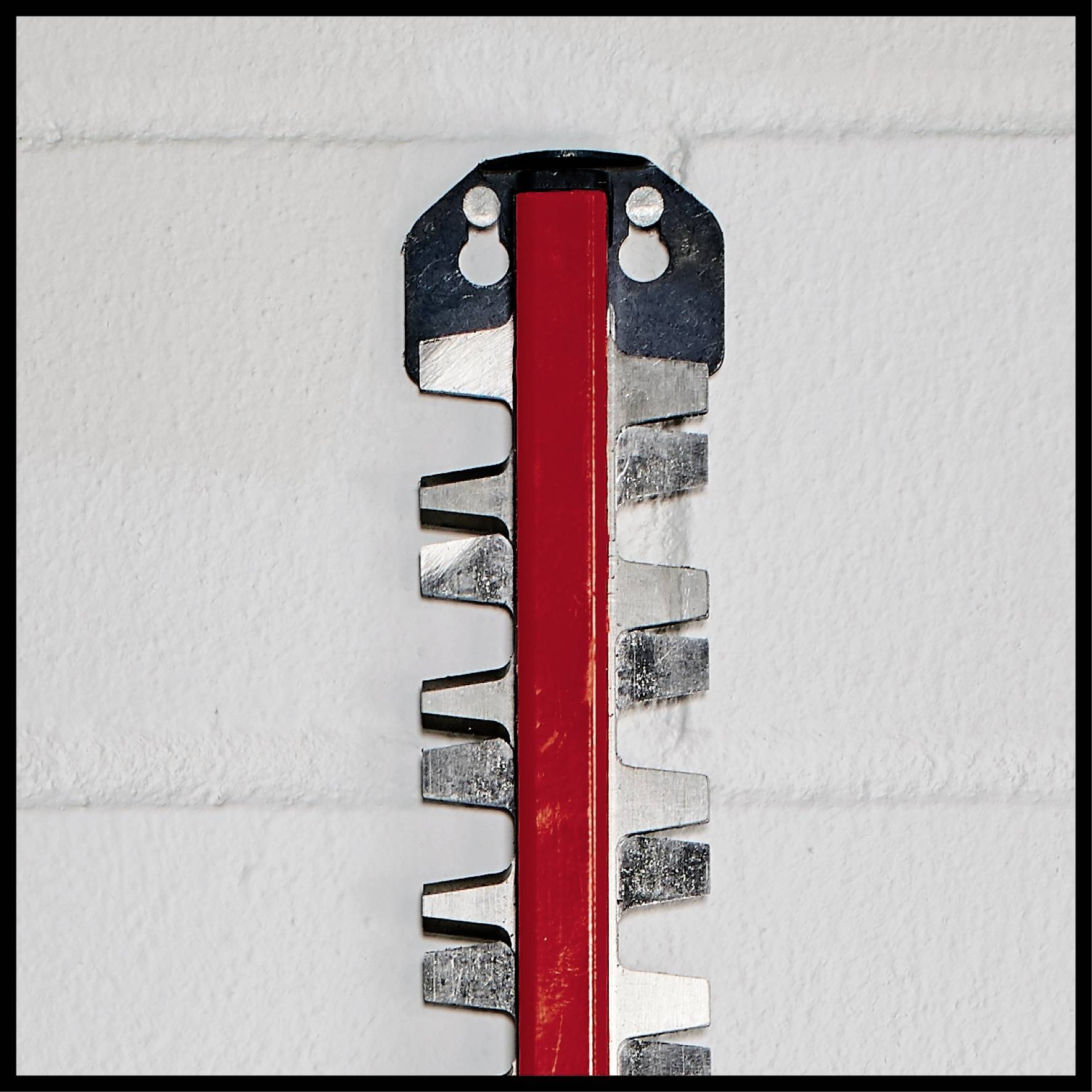 Close-up of a metal saw blade with serrated edges and a red central section against a white background.