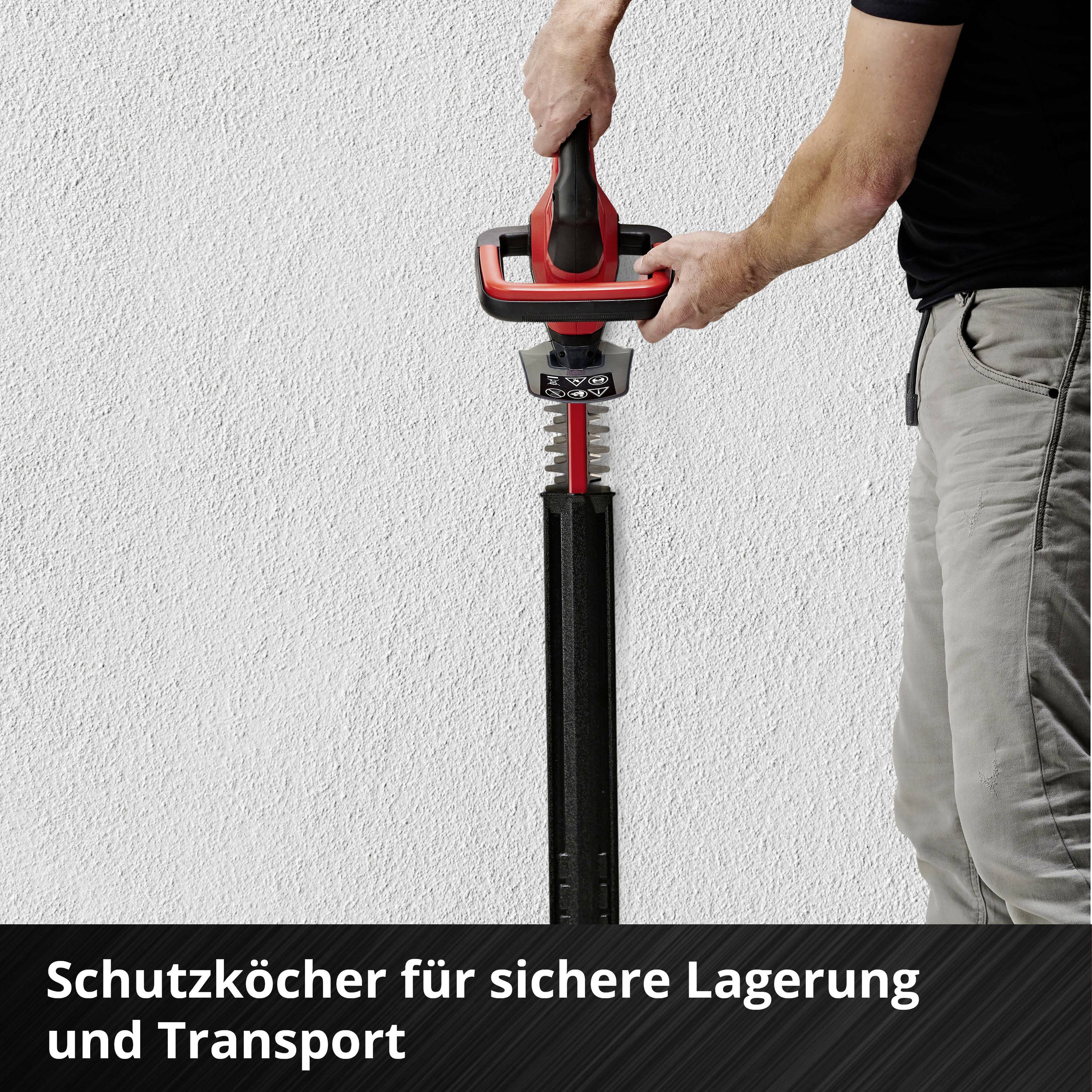 A person is holding an electric tool with a protective blade against the wall. Text in the image: 'Protective holster for safe storage and transport'.