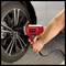 A person is using an electric impact wrench to secure the wheel nuts of a car.