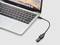 A laptop with a USB drive connected via an adapter cable. The screen displays a landscape.