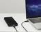 External hard drive connected to a laptop on a table. The laptop displays a wallpaper with a starry sky.