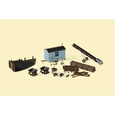 Set of miniature construction site equipment: Shovels, wheelbarrows, conveyor belt, wooden planks, gravel heaps and carts on a light yellow background.