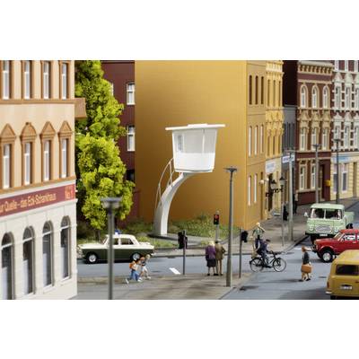 A model city with cars, pedestrians and cyclists. At its centre stands a modern, white house with a curved staircase.